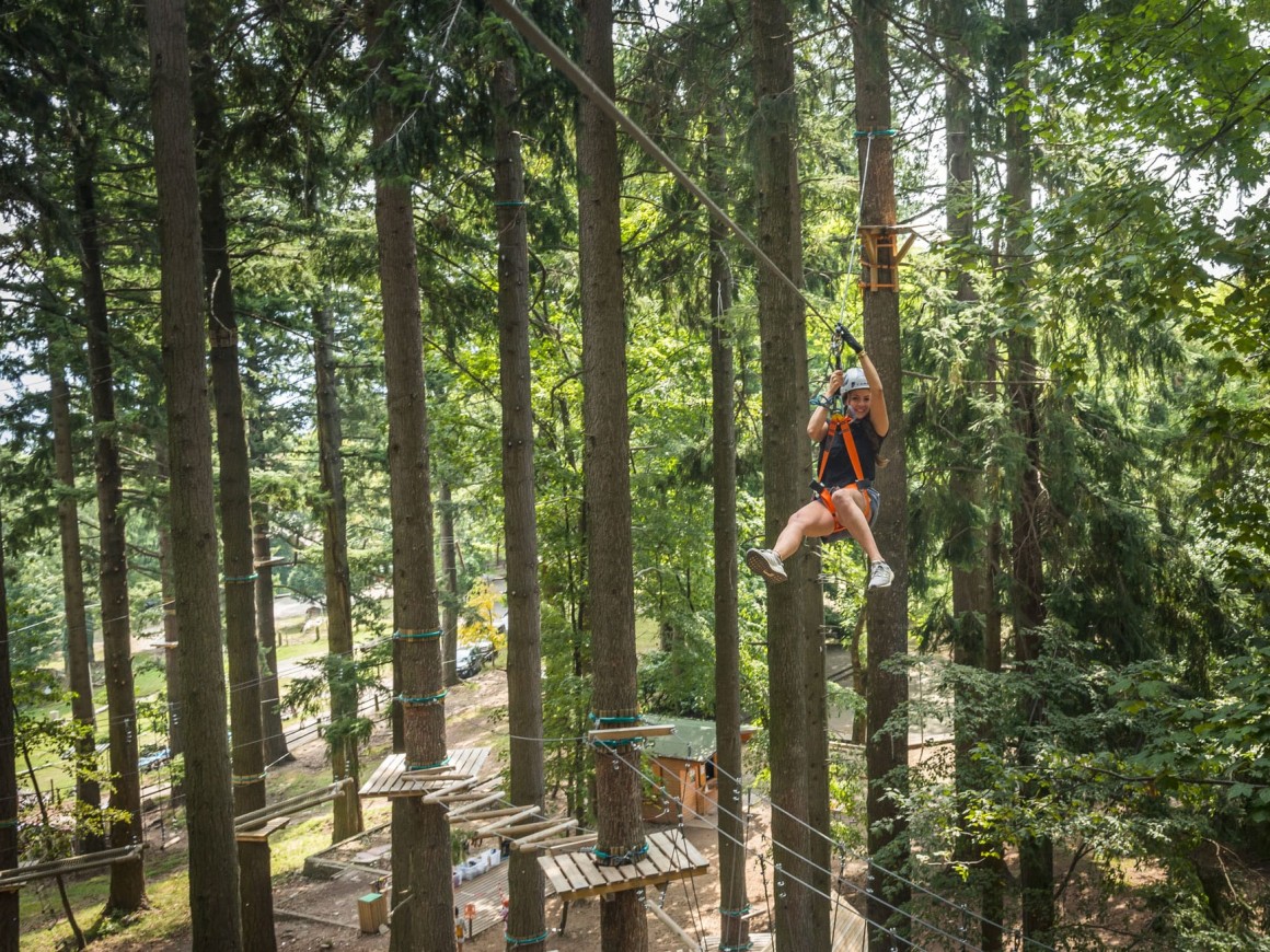 Ragazza si diverte sul percorso teleferiche al parco avventura di Albavilla